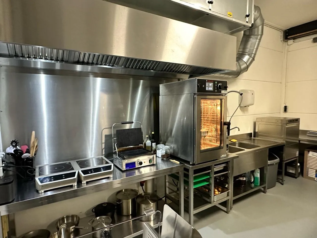 Keuken met afzuigkap en combisteamer bij Di Niente